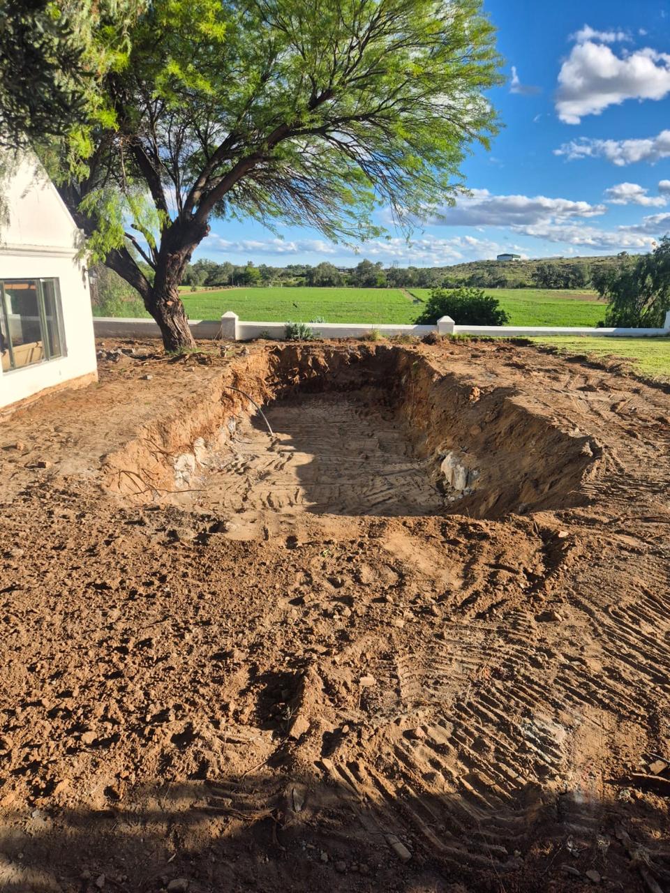 Pool excavation beside a farmhouse